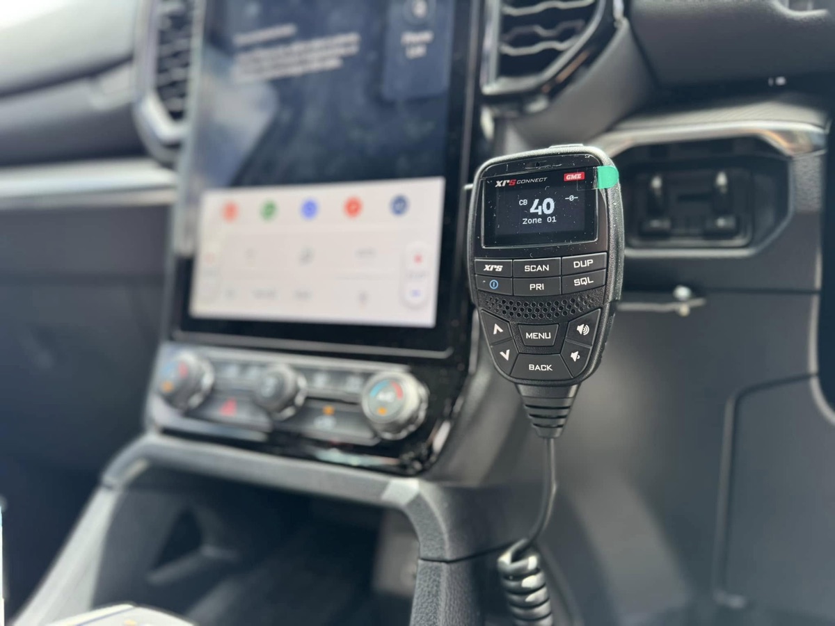 GME XRS Connect UHF handset mounted beside a large touchscreen