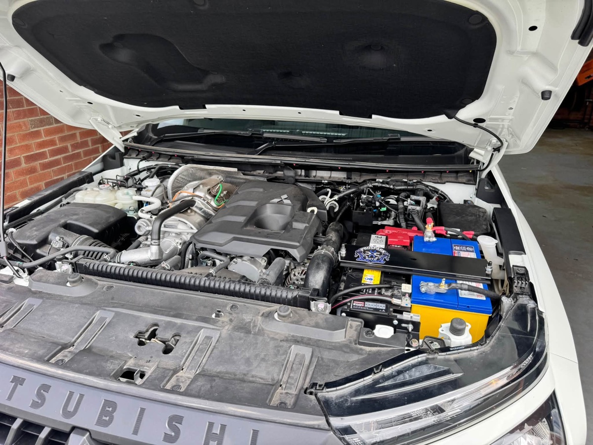 Mitsubishi engine bay with dual batteries and a REDARC BCDC charger under the bonnet