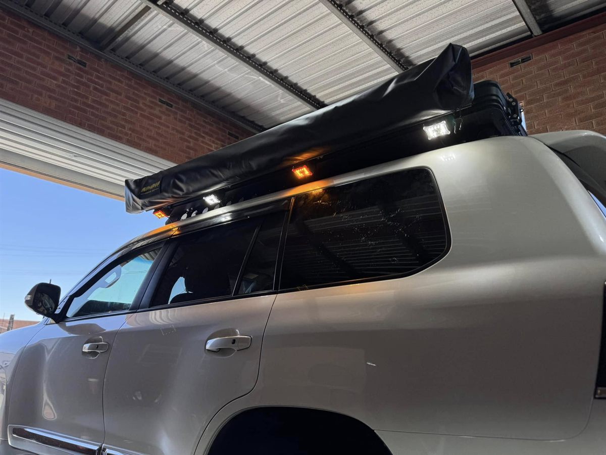 Awning-side camp light fitted to a roof rack on a LandCruiser